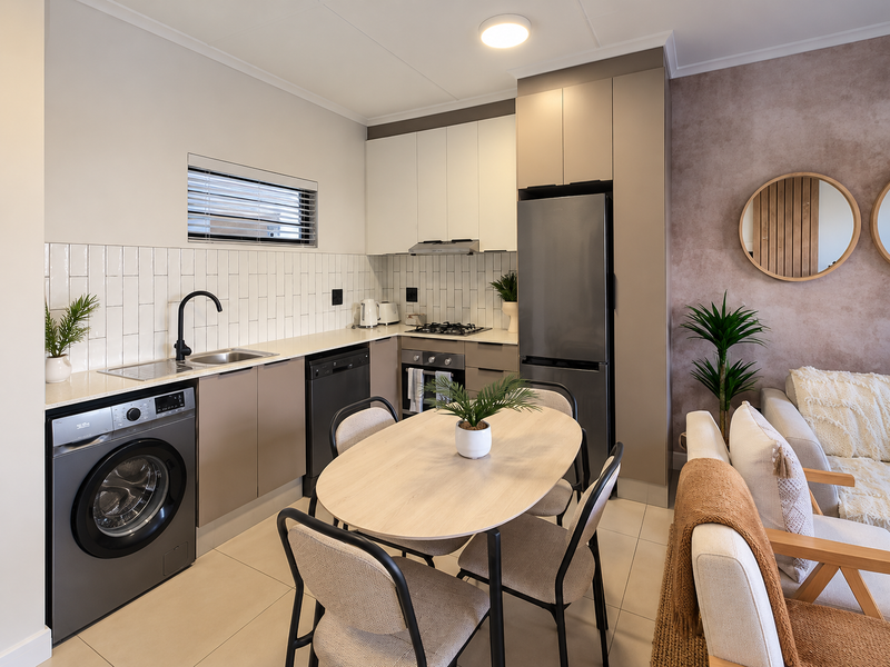 Modern open-plan kitchen featuring sleek cabinetry, subway tile backsplash, integrated appliances, and tiled flooring, seamlessly flowing into the living area.