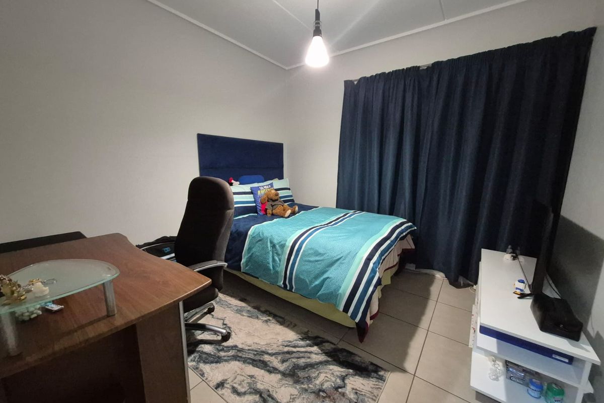 A functional bedroom featuring tiled flooring and neutral wall finishes, providing a comfortable and practical living space.