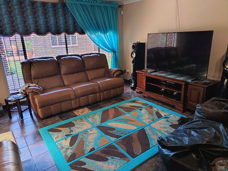 A comfortable living room featuring tiled flooring and a large window, providing a functional space for relaxation and entertainment.