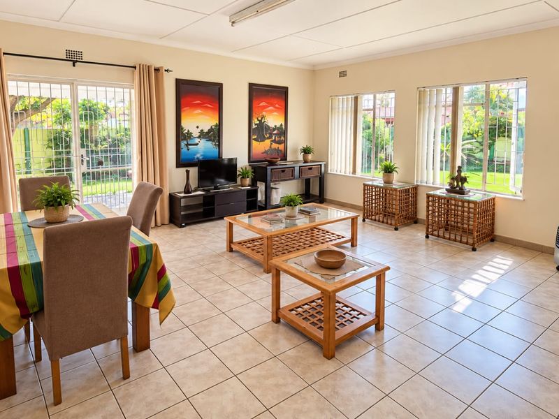 Spacious open-plan living and dining area featuring neutral tiled flooring, large windows with security bars, and direct access to the garden through sliding doors.