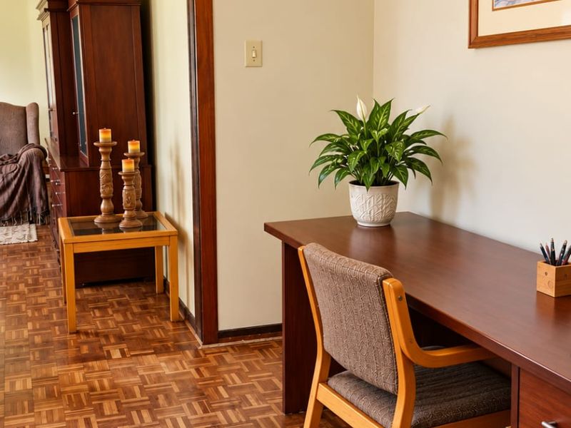 A well-maintained home office featuring classic parquet flooring, timber door frames, and a decorative pendant light fixture.