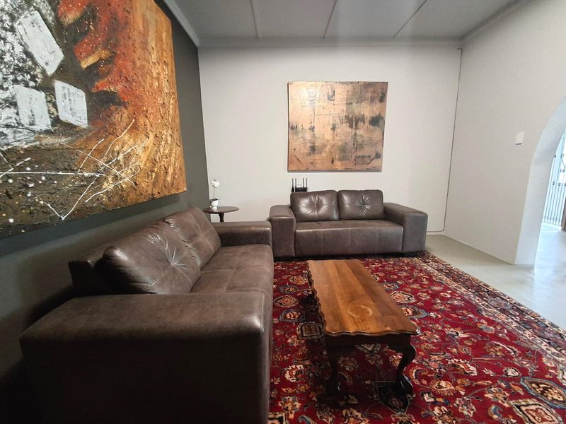 A spacious living room featuring neutral walls, tiled flooring, and an arched entryway, providing a comfortable and versatile living area.