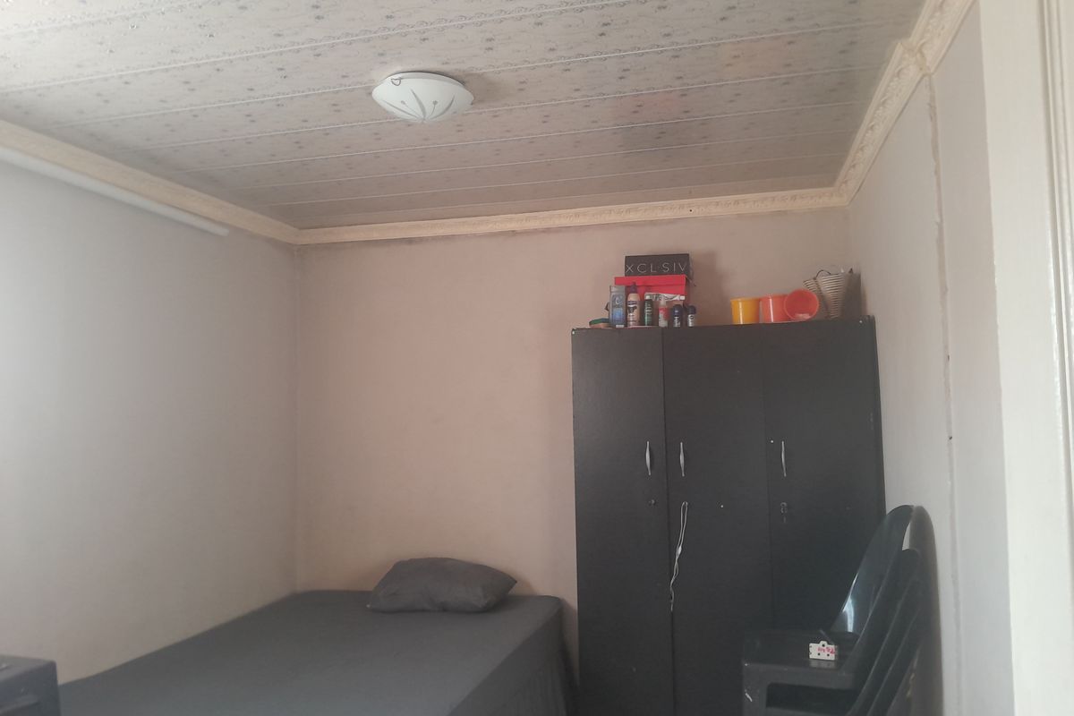 A bedroom featuring a textured ceiling with decorative molding. The space requires cosmetic updates to improve the overall finish and appeal.