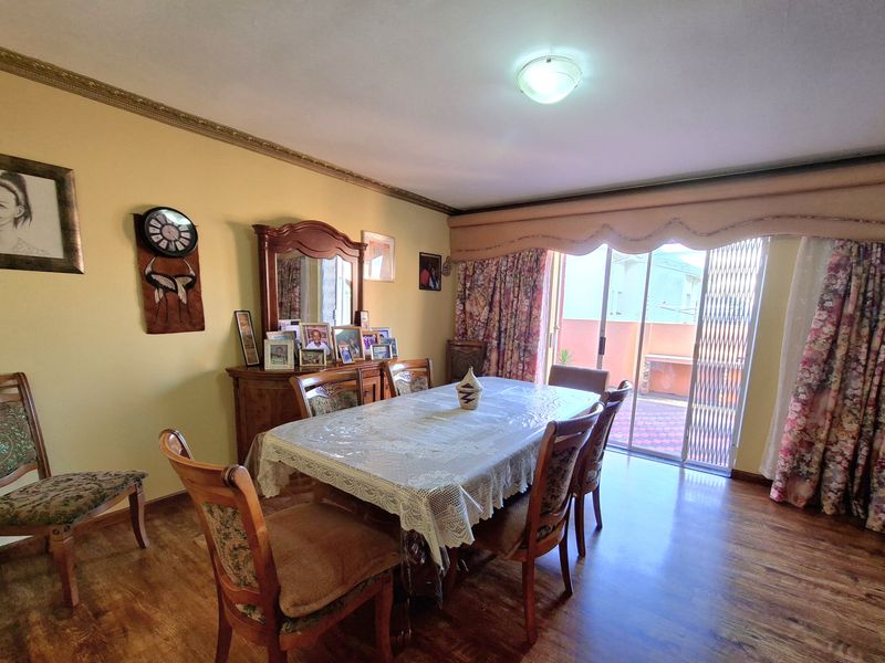 A dining room featuring laminate flooring and a sliding glass door providing access to an outdoor patio area.