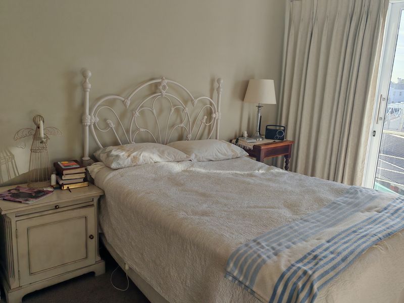 A cozy bedroom featuring carpet flooring and a sliding glass door that provides natural light and access to an outdoor area.