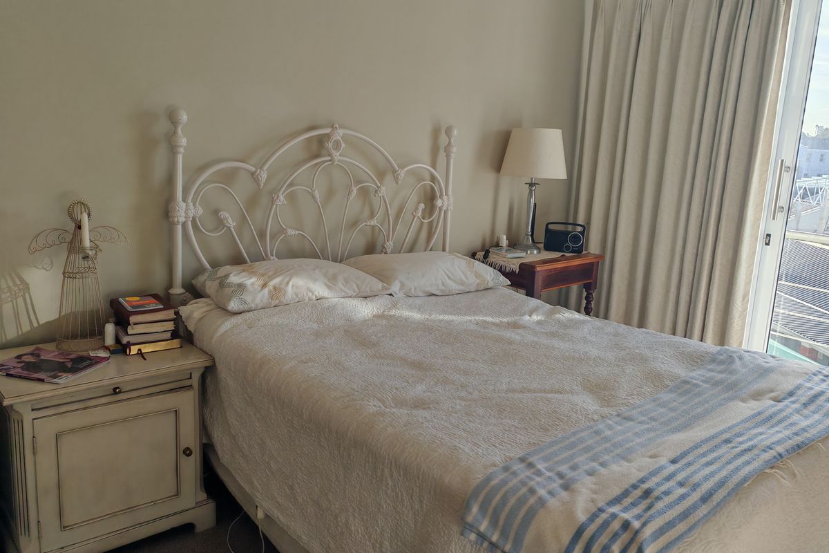A cozy bedroom featuring carpet flooring and a sliding glass door that provides natural light and access to an outdoor area.