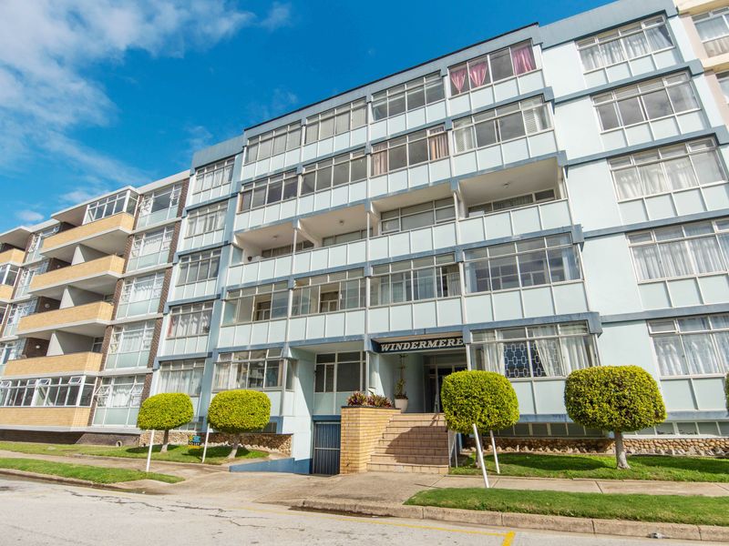Front elevation of the Windermere apartment complex, featuring multi-story residential units with enclosed balconies and a paved entrance.