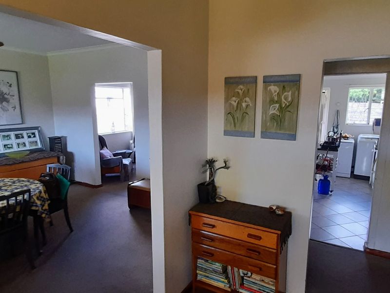 A central hallway connecting the living area and kitchen, featuring a mix of carpeted and tiled flooring with an open-plan layout.