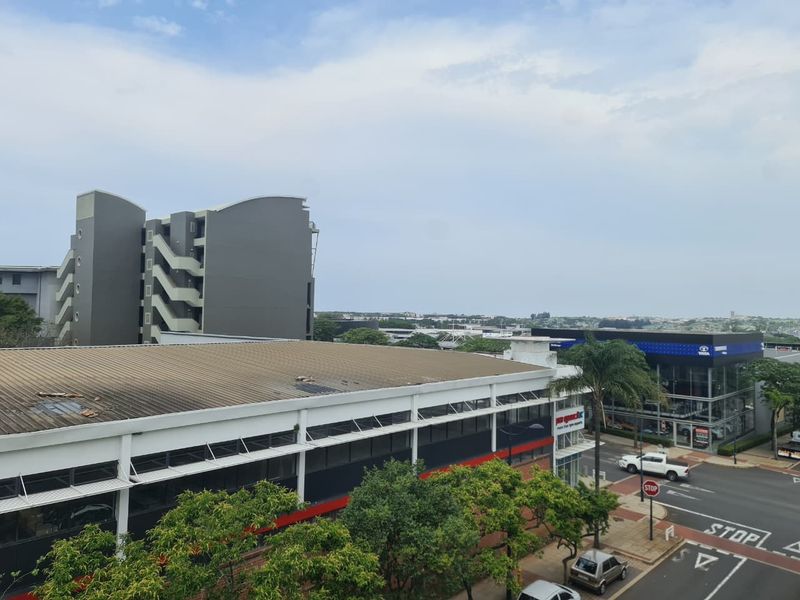 An elevated urban view overlooking surrounding commercial buildings, street infrastructure, and neighborhood landscape.