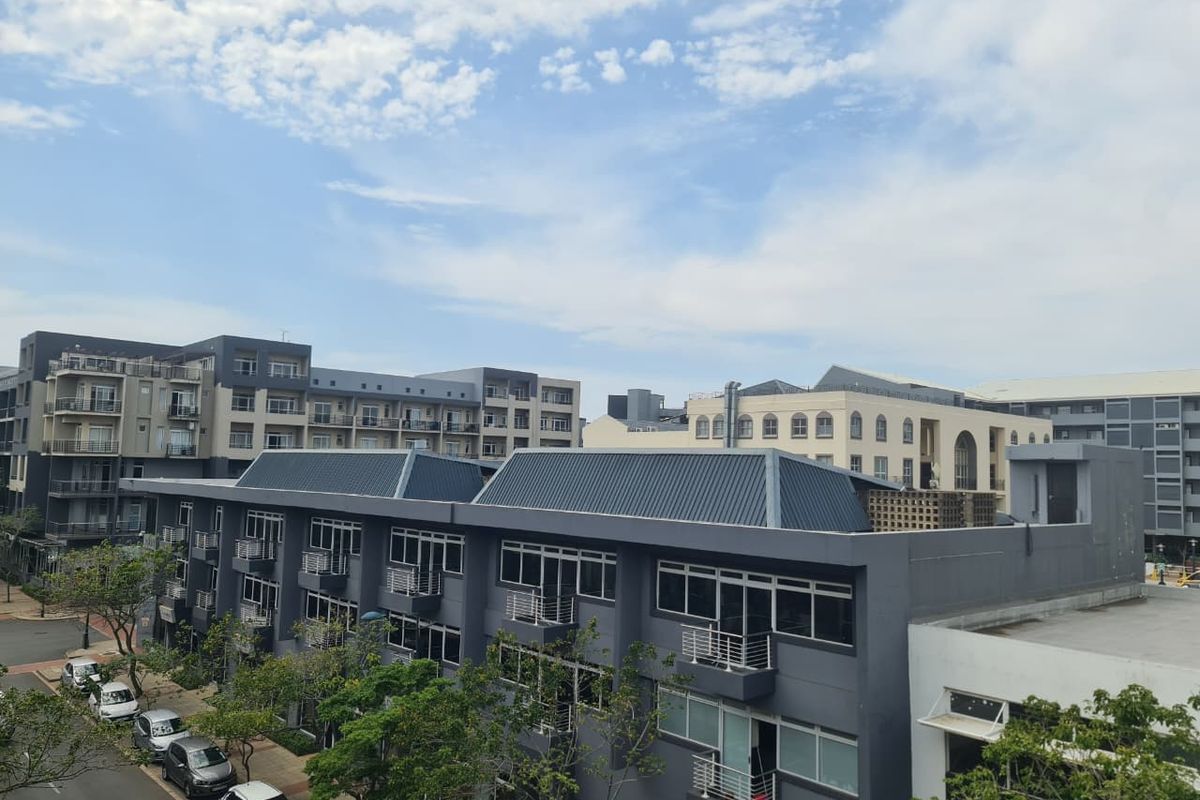 An elevated view of the surrounding apartment complex architecture, showcasing modern building facades, metal roofing, and residential balconies.