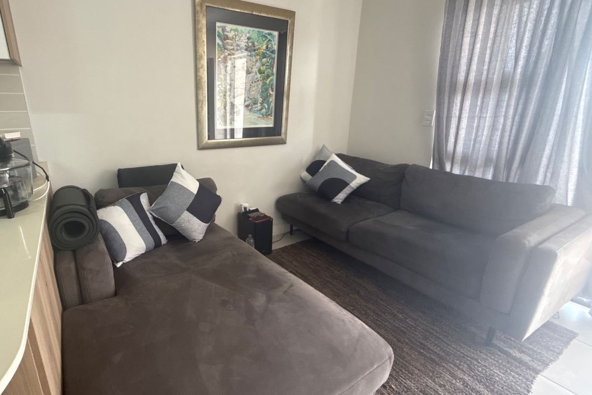 A comfortable living area featuring tiled flooring and a sliding glass door that provides natural light.