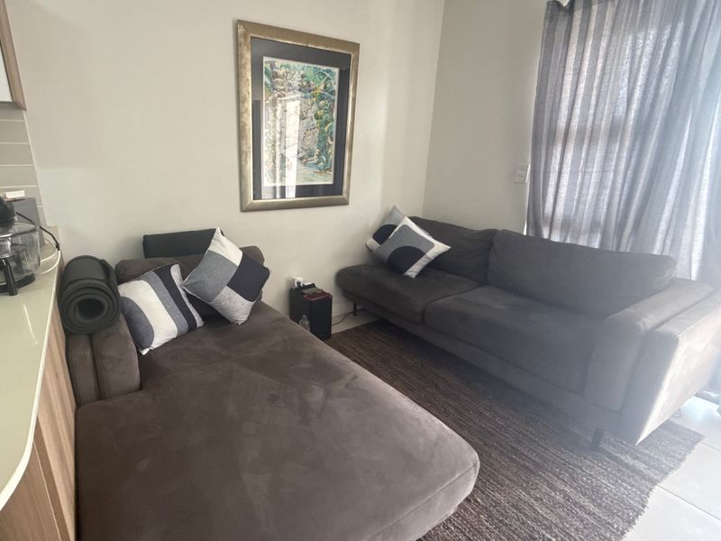 A comfortable living area featuring tiled flooring and a sliding glass door that provides natural light.