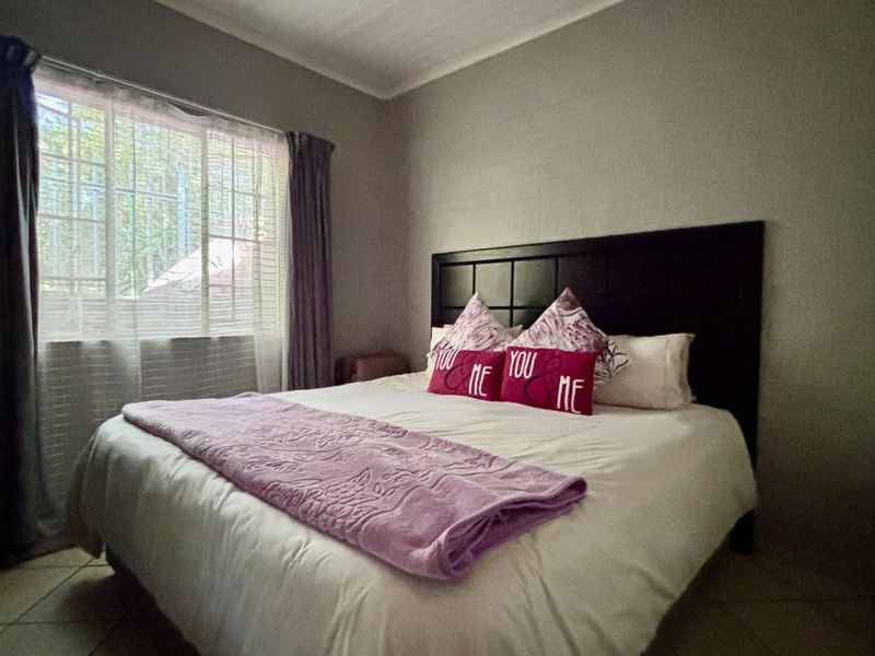 A functional bedroom featuring tiled flooring and a built-in cupboard, providing a comfortable and practical living space.
