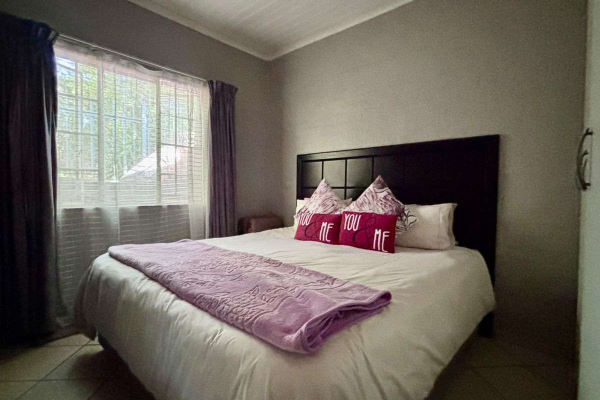 A functional bedroom featuring tiled flooring and a built-in cupboard, providing a comfortable and practical living space.