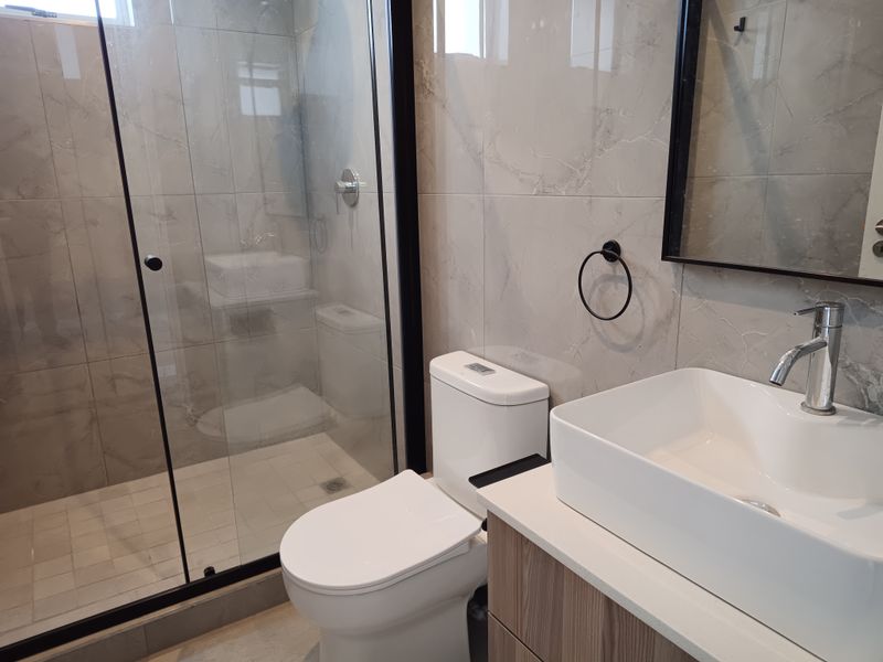 Modern bathroom featuring a glass-enclosed shower, contemporary vessel sink with vanity cabinet, and high-quality tiled finishes.
