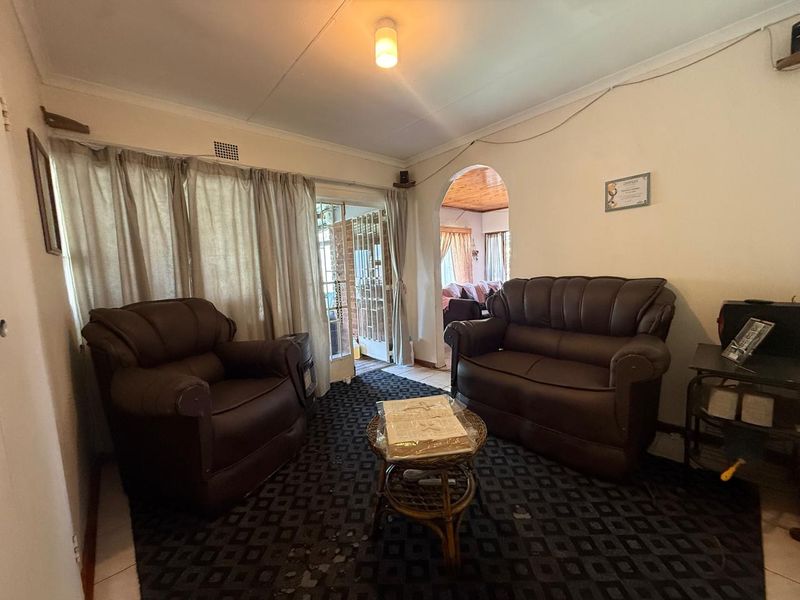 A living room featuring an arched entryway, sliding glass door access to the exterior, and a ceiling light fixture.