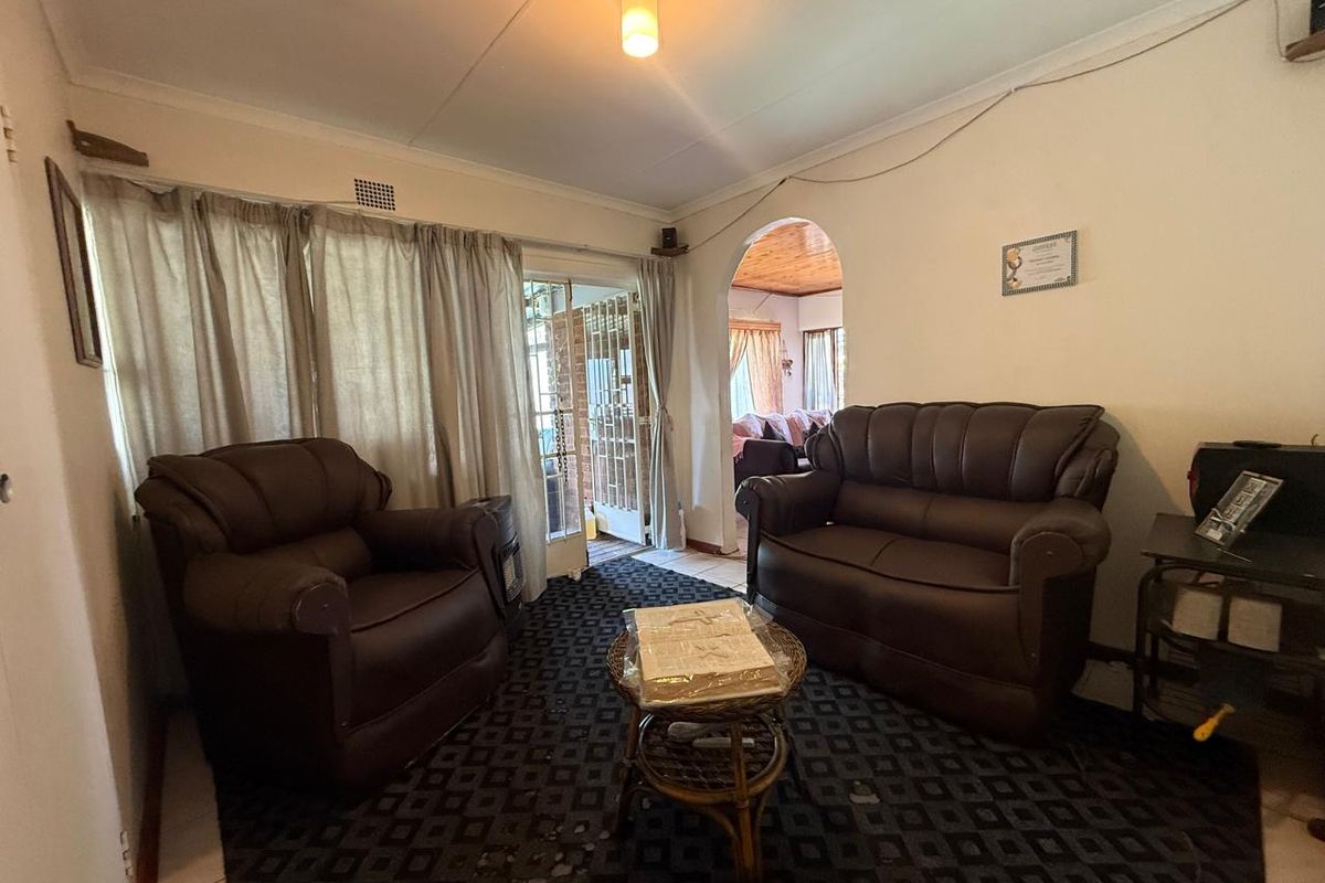 A living room featuring an arched entryway, sliding glass door access to the exterior, and a ceiling light fixture.