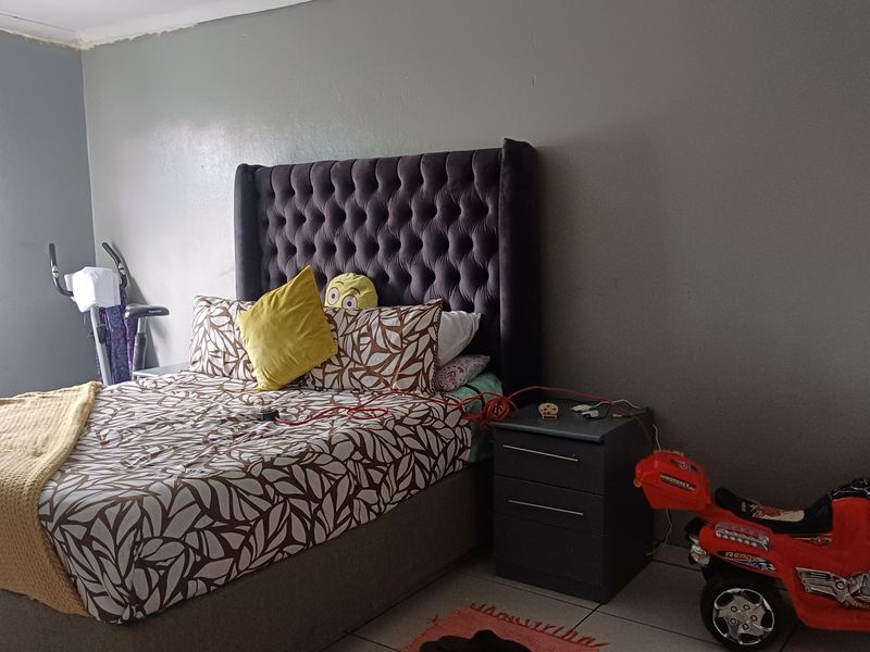 A bedroom featuring tiled flooring and neutral wall tones, providing a functional space for rest.
