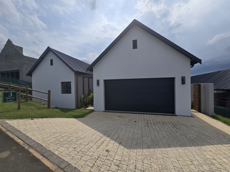 Modern residential property featuring a double garage with a paved driveway and clean architectural lines.