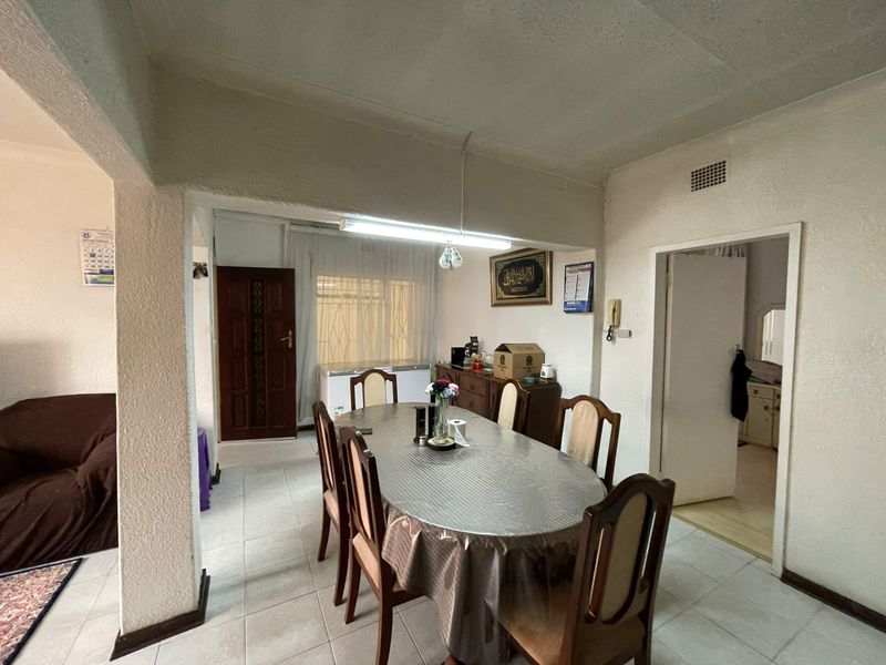 A functional dining area featuring tiled flooring and a textured ceiling, providing a central space for family meals.