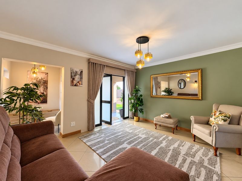 A well-maintained living room featuring tiled floors, an accent wall, and a sliding glass door providing access to the outdoor area.