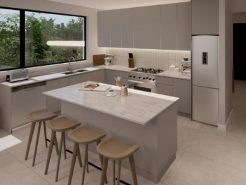 Modern kitchen featuring a central island with stone countertops, sleek cabinetry, integrated appliances, and a large window overlooking the exterior.