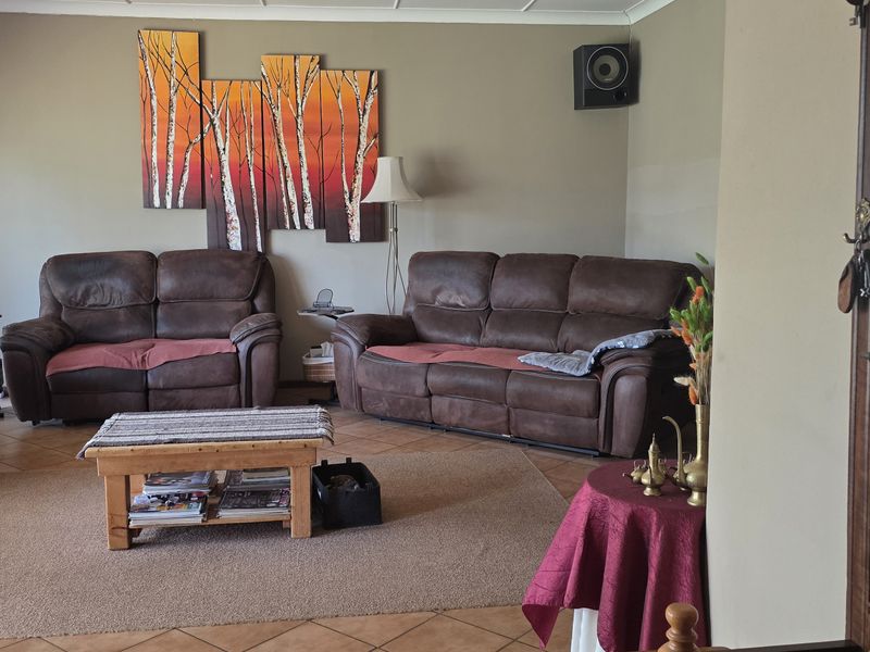 A spacious living room featuring tiled flooring and wall-mounted speakers, offering a comfortable area for relaxation and entertainment.