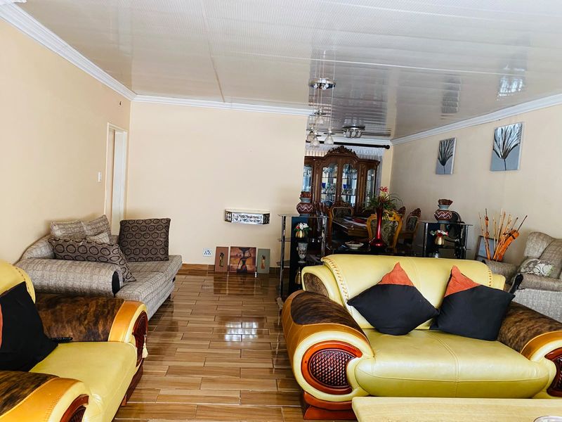 An open-plan living and dining area featuring tiled flooring and coved ceilings, providing a functional space for family gatherings and entertaining.