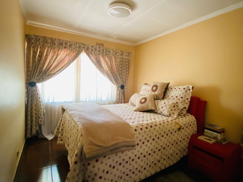 A cozy bedroom featuring tiled flooring and a central ceiling light fixture, offering a functional and comfortable living space.