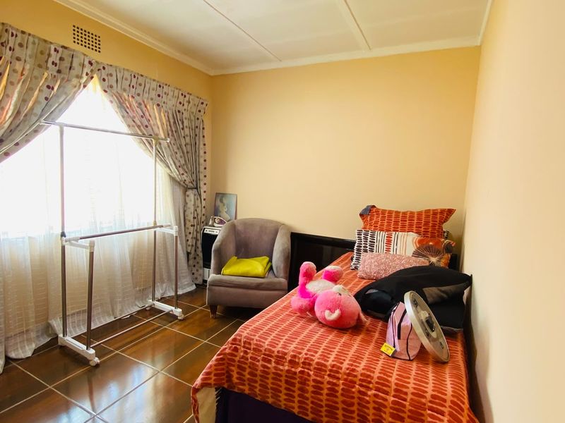 A bedroom featuring tiled flooring and a ceiling vent, requiring minor cosmetic updates to the ceiling and wall finishes.