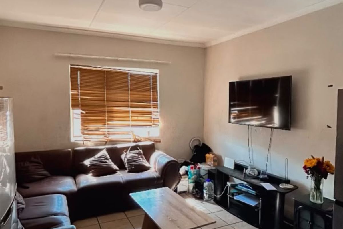A living room featuring tiled flooring and venetian blinds, requiring minor cosmetic updates to improve the overall aesthetic and finish.