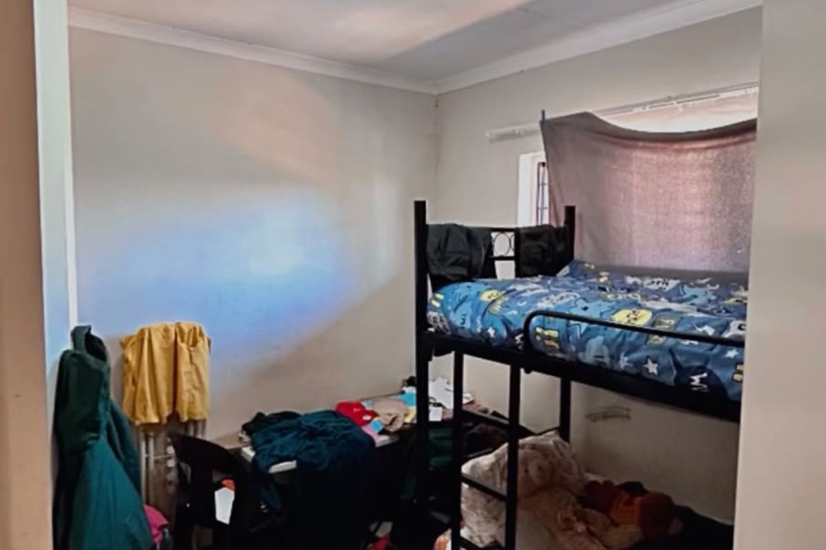 A compact bedroom featuring tiled flooring and a standard ceiling light fixture, providing a functional space for sleeping.