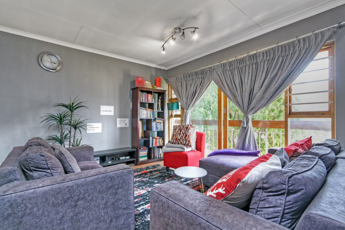 A comfortable living room featuring a large sliding glass door with timber frames, providing natural light and access to the outdoor area.