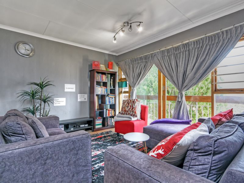 A comfortable living room featuring a large sliding glass door with timber frames, providing natural light and access to the outdoor area.