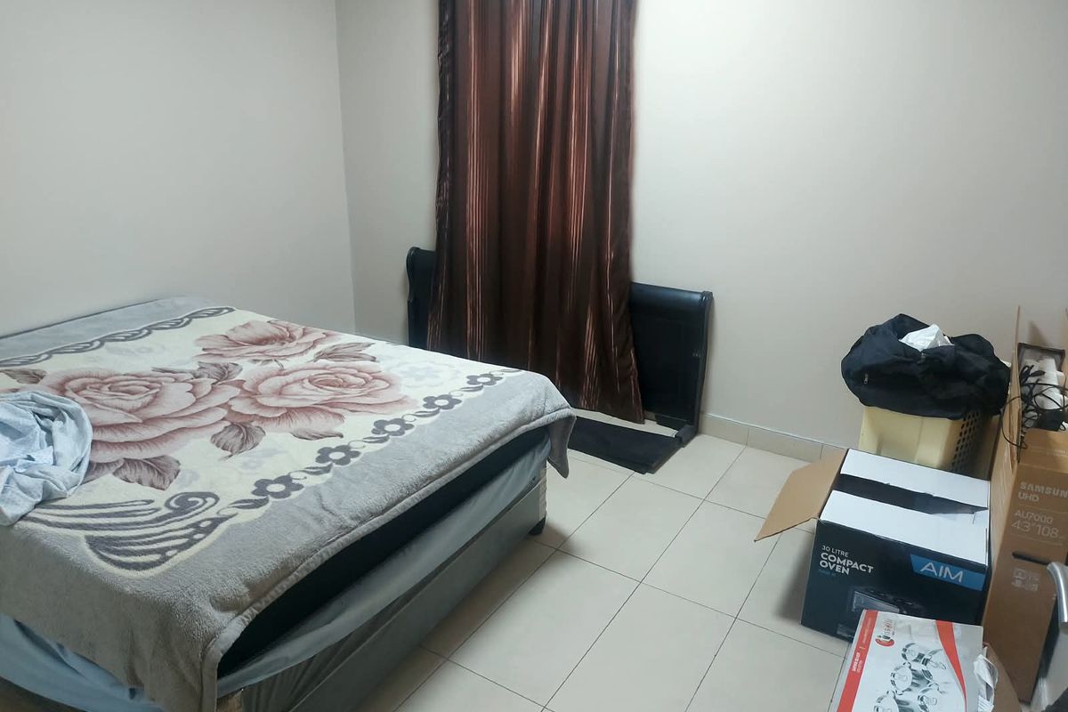A simple bedroom featuring tiled flooring and neutral wall finishes, providing a functional space ready for personalization.