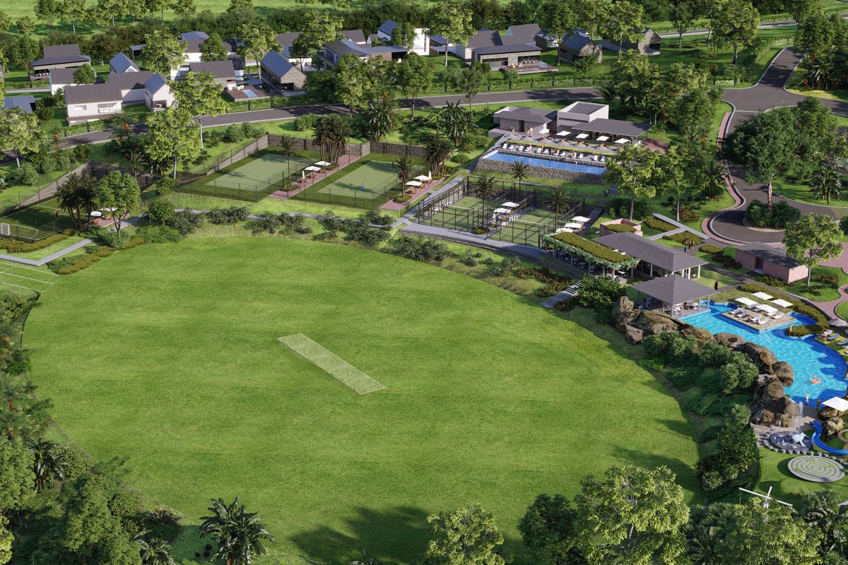 Aerial view of a residential estate featuring a cricket pitch, tennis courts, swimming pool, clubhouse, and landscaped recreational grounds.