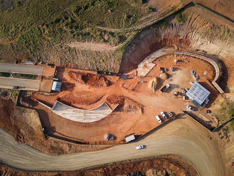 Aerial view of a residential vacant land development site showing ongoing earthworks, retaining wall construction, and site access infrastructure.