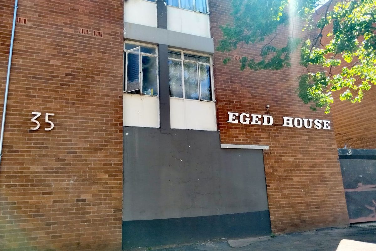 Front exterior view of Eged House, featuring a traditional brick facade and building signage.