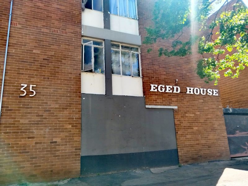 Front exterior view of Eged House, featuring a traditional brick facade and building signage.