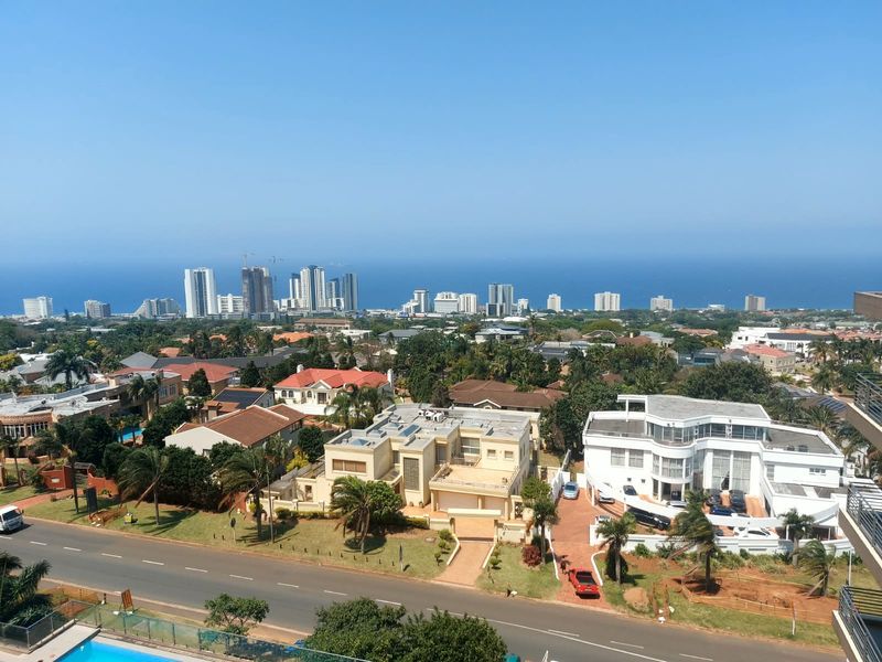 Elevated panoramic view overlooking the surrounding residential neighborhood, coastal landscape, and distant ocean horizon.