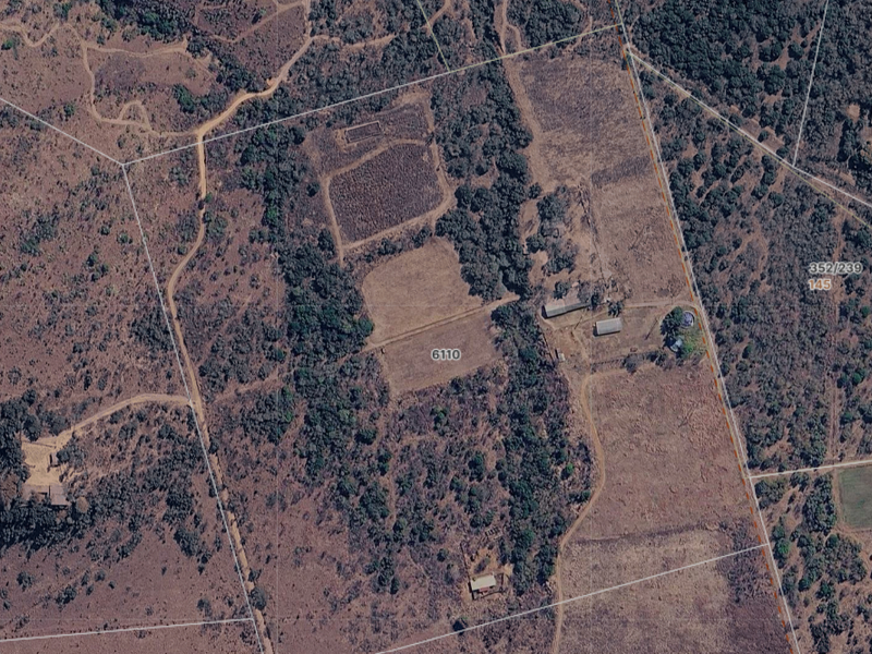 An aerial view of the farm property showing land layout, boundary lines, access roads, and surrounding vegetation.