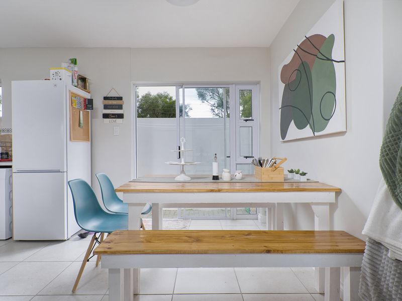 Bright open-plan dining and utility area featuring tiled flooring and direct access to the rear patio through a sliding glass door.