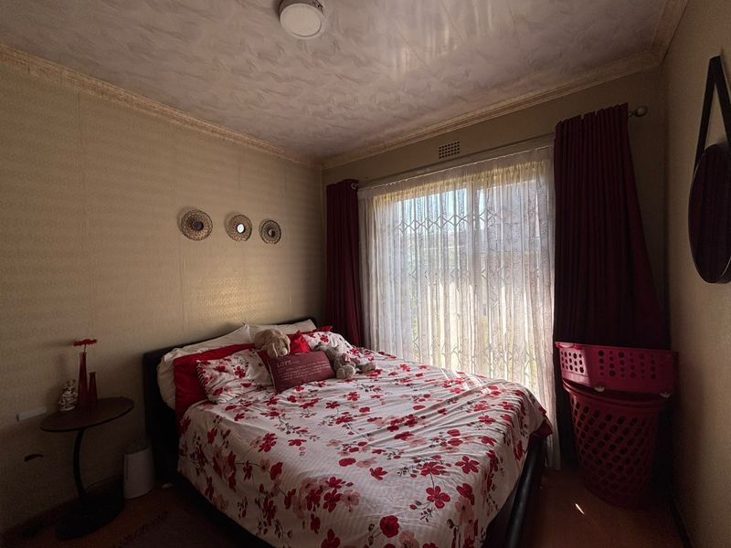 A bedroom featuring a sliding door with a security gate, ceiling cornice, and a ventilation grille.