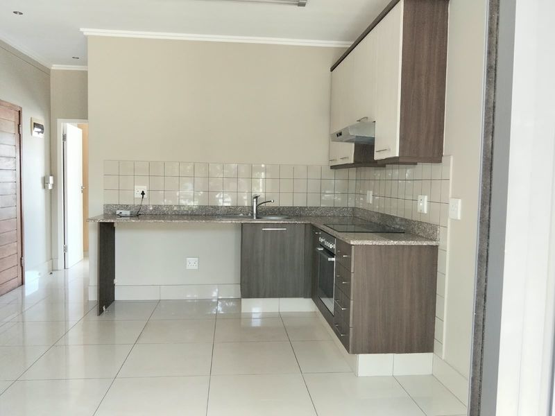 A clean, modern kitchen featuring built-in cabinetry, granite countertops, a tiled backsplash, and integrated appliances, offering a functional and well-maintained cooking space.