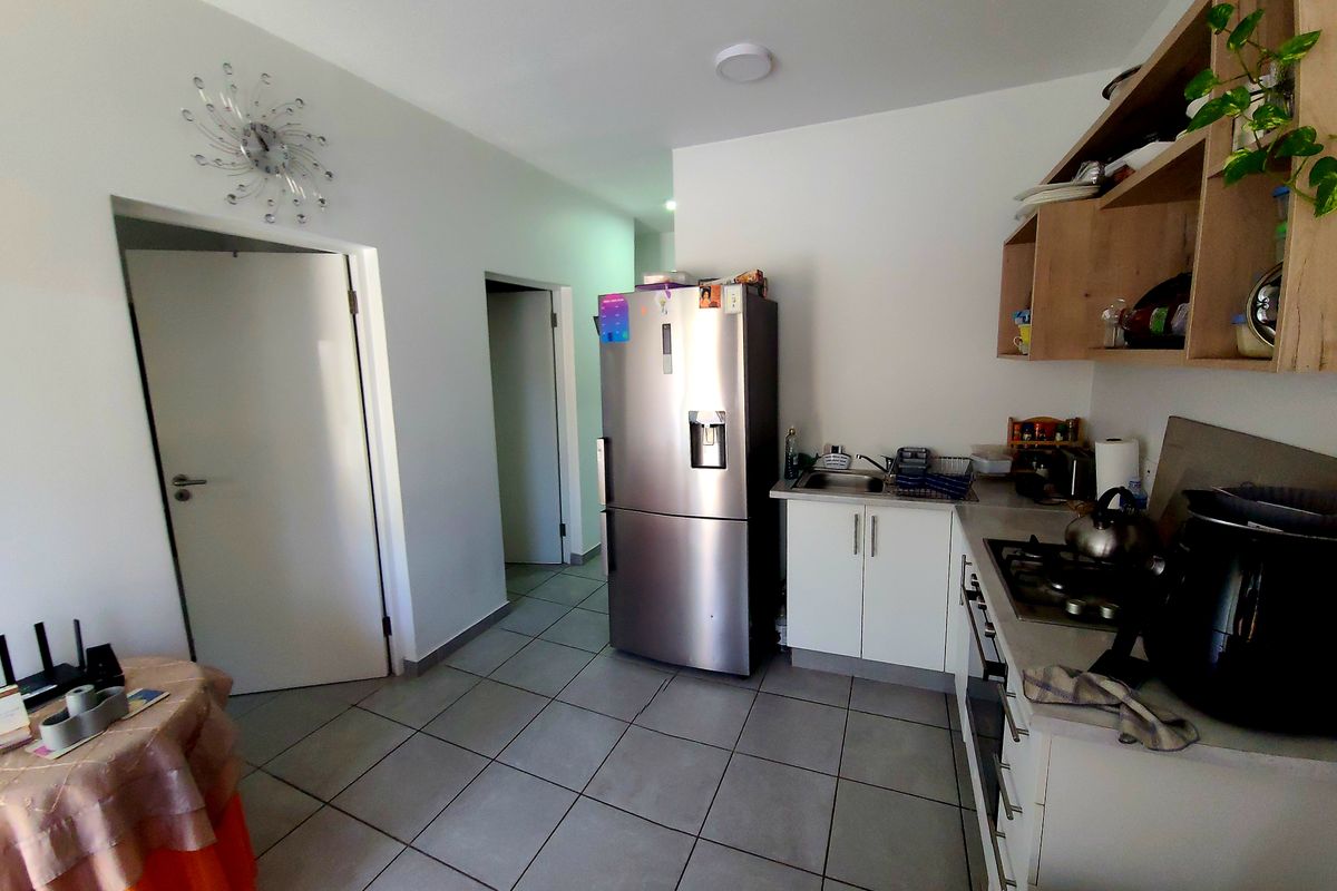 Compact kitchen featuring tiled flooring, built-in cabinetry, gas hob, and oven, providing a functional workspace within the apartment.