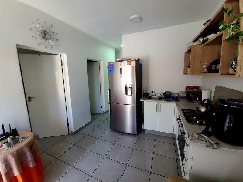 Compact kitchen featuring tiled flooring, built-in cabinetry, gas hob, and oven, providing a functional workspace within the apartment.