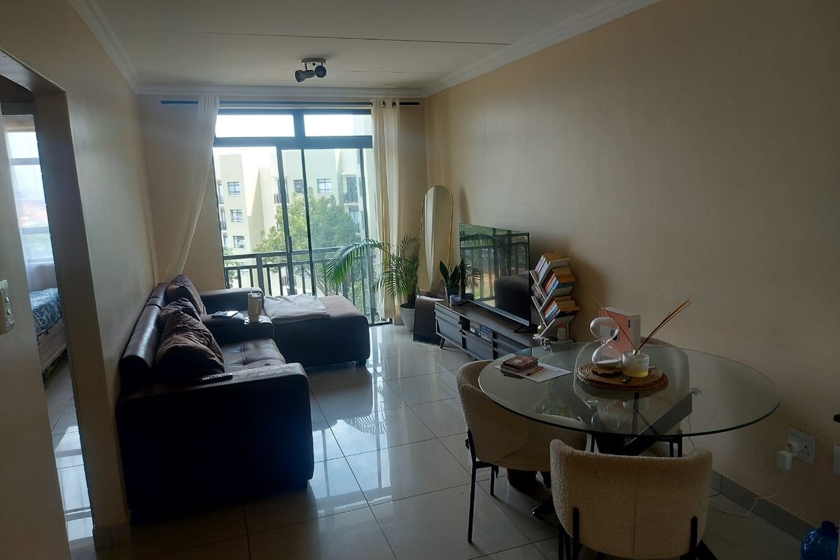 Open plan living and dining area featuring tiled flooring and a large sliding glass door leading to a balcony.