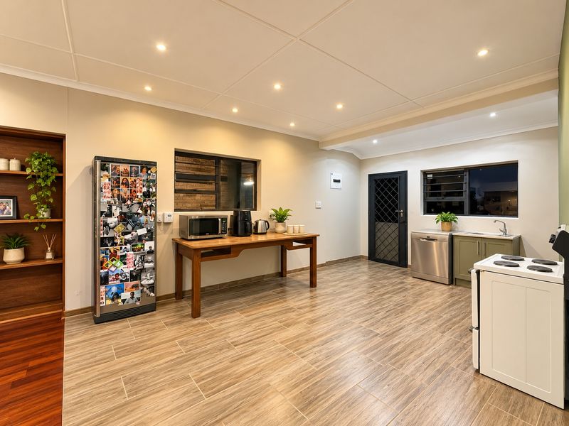 A functional kitchen featuring tiled flooring, recessed lighting, built-in shelving, and essential appliances including a stove and dishwasher.