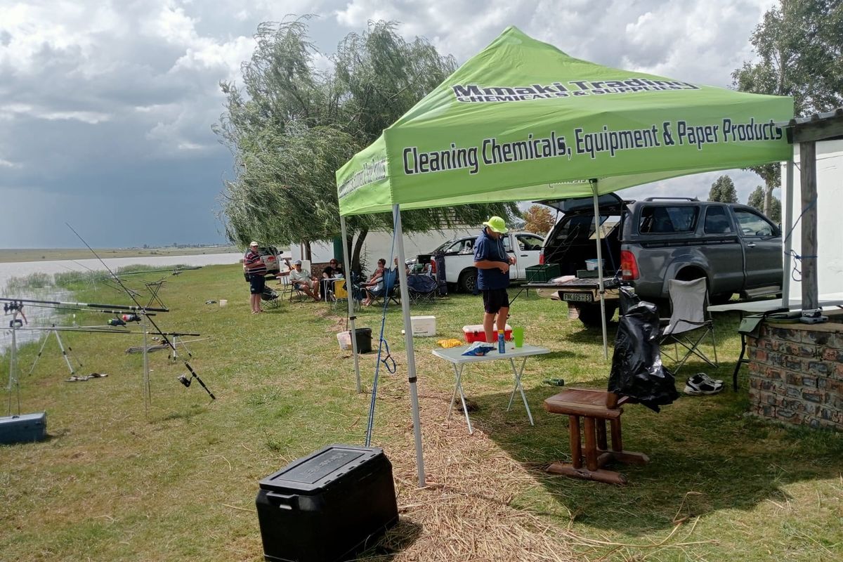 A view of the rear outdoor area of the farm property, featuring open grass space near the water's edge.