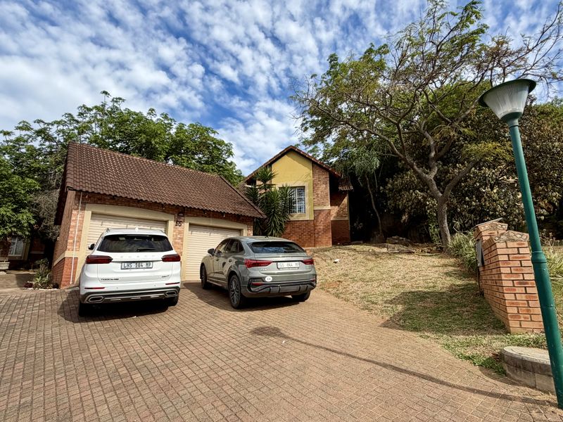 Front exterior view of a facebrick house featuring a double garage and a paved driveway.